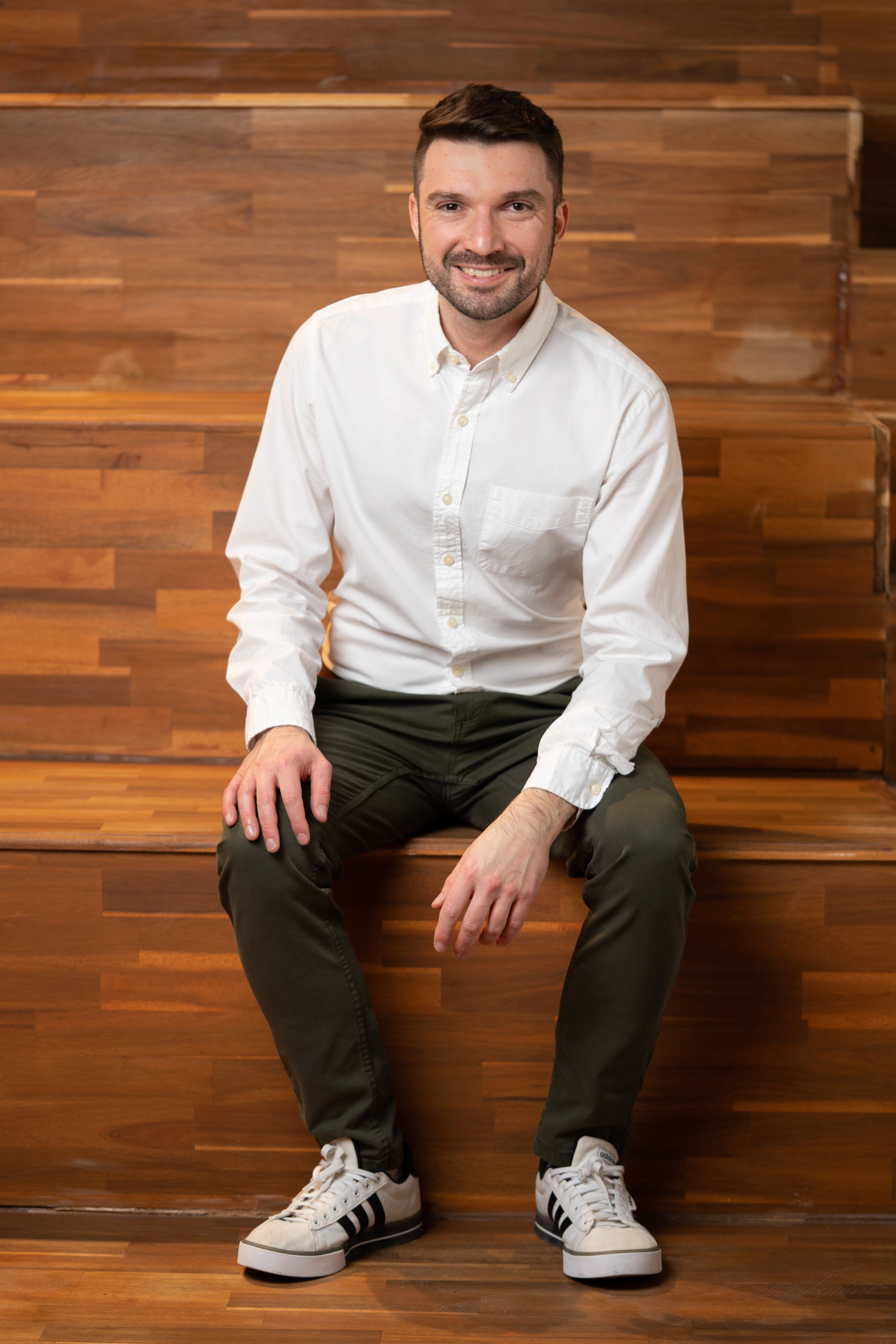 מצולם יושב על יציע עשוי עץ